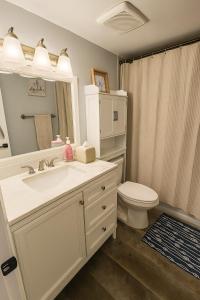 a white bathroom with a sink and a toilet at Oceanfront Retreat Private Beach New Smyrna Beach in New Smyrna Beach