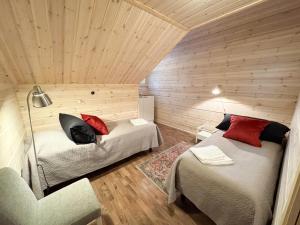 ein Zimmer mit 2 Betten und einem Stuhl darin in der Unterkunft Villa Otso-huoneistot Saniaistie in Vuokatti