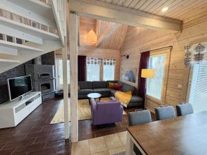 ein Wohnzimmer mit Sofa und Fernseher in der Unterkunft Villa Otso-huoneistot Saniaistie in Vuokatti