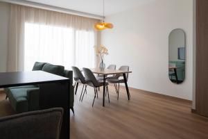 a dining room with a table and chairs at Alora Apartamentos Mérida in Merida +10 photos