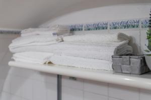 ein Stapel Handtücher auf einem Regal in einem Badezimmer in der Unterkunft Casa Carmela 53 in Ragusa + 13 Fotos