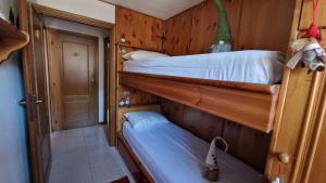 Cette chambre comprend 2 lits superposés dans un couloir. dans l'établissement Incantevole appartamento ai piedi del Passo Giau, à Selva di Cadore