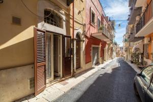eine Gasse mit Gebäuden und einem Auto auf einer Straße in der Unterkunft Casa Carmela 53 in Ragusa