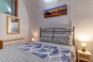 ein Schlafzimmer mit einem Bett und zwei Nachttischen in der Unterkunft Casa Carmela 53 in Ragusa