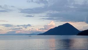 a large body of water with a mountain in the background at Bamboo Payag Batangas in Laurel