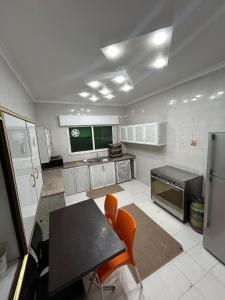 a kitchen with a table and orange chairs in it at Toum's Apartments 2 in Amman