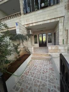a building with a stone walkway in front of it at Toum's Apartments 2 in Amman