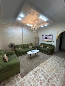 a living room with green couches and a table at Toum's Apartments 2 in Amman