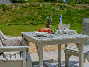 a white table with a bowl of fruit and a bottle of wine at 1 Bed in Boscastle 95316 in Camelford +17 photos