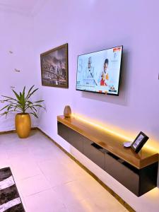 ein Wohnzimmer mit einem Fernseher an der Wand in der Unterkunft B&L Short-let Apartments in Port Harcourt + 7 Fotos