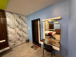 a bedroom with a mirror and a bed and a desk at Erode Kongu mess in Chennai