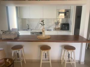 a kitchen with a counter with stools and a counter top at Rony by Best Holidays Fuerteventura in Corralejo
