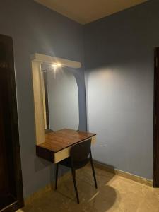 a dressing table with a mirror on a wall at Erode Kongu mess in Chennai +1 photo