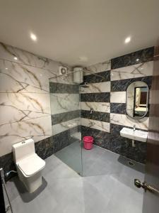 a bathroom with a toilet and a sink and a mirror at Erode Kongu mess in Chennai