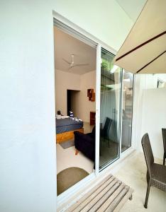 a room with a sliding glass door leading to a bedroom at The Wave Dhigurah in Dhigurah +12 photos