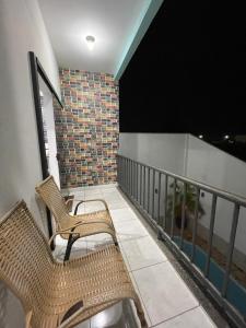 two chairs sitting on a balcony at night at Flat Centro 302 in Tangara da Serra