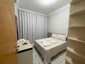a small bedroom with a bed and a closet at Flat Centro 302 in Tangara da Serra