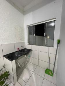 a bathroom with a sink and a window at Flat Centro 302 in Tangara da Serra +6 photos