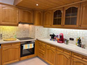 a kitchen with wooden cabinets and a stove top oven at Ferienwohnung Altstadt Freistadt in Freistadt