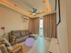a living room with a couch and a ceiling fan at Urban Suites - Dolphin's Home in Jelutong