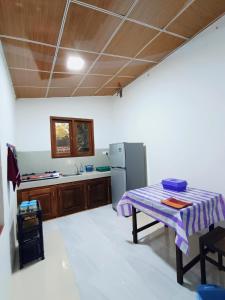 a kitchen with a table and a refrigerator at Villa lovely birds mirissa in Mirissa +19 photos