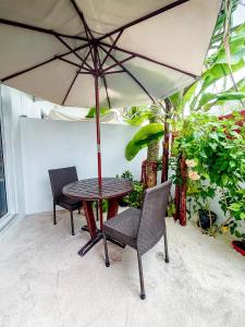 a table and chairs under an umbrella on a patio at The Wave Dhigurah in Dhigurah