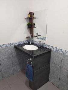 a bathroom with a sink and a mirror at Dptos Ceci in Centenario +2 photos