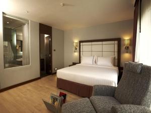 a hotel room with a bed and a couch at Sukhumvit Suites Hotel in Bangkok