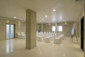 a large room with white chairs and a stage at Hotel Metropolitan in Jaipur