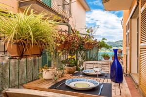 a table with plates and wine glasses on a balcony at CameraPortivè Sea view & AC in Portovenere