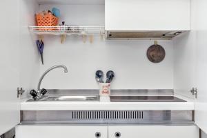 a kitchen with white cabinets and a sink and a sink at CameraPortivè Sea view & AC in Portovenere