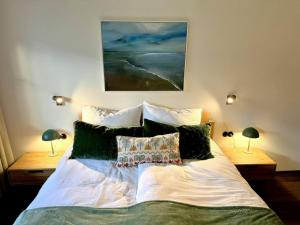 a bedroom with a bed with two lamps and a painting at Strumpfburg by Dollop Living in Kramsach