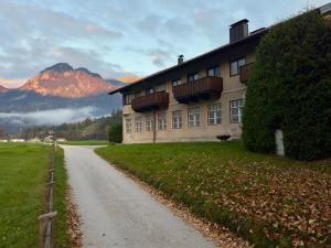 a house on a road next to a mountain at Strumpfburg by Dollop Living in Kramsach
