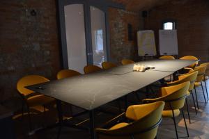une salle de conférence avec une longue table et des chaises dans l'établissement Maranello Resort Borgo Torre della Montina, à Maranello