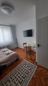 Un dormitorio con una cama, un escritorio y una mesa. en Studio - city center, en Chişinău