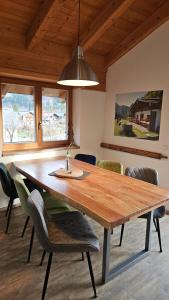 ein Esszimmer mit einem Holztisch und Stühlen in der Unterkunft Chalet Steinplatte in Reit im Winkl