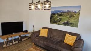 a living room with a couch and a flat screen tv at Chalet Steinplatte in Reit im Winkl