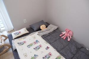 un lit avec une poupée dessus dans une chambre dans l'établissement 광안리해수욕장 30초 베이비 맞춤 풀옵션 패밀리 안심 숙소, à Busan