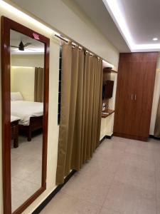 ein Zimmer mit einem Spiegel und ein Schlafzimmer mit einem Bett in der Unterkunft Vishnu VAASAM Serviced Apartment Srirangam in Tiruchchirāppalli