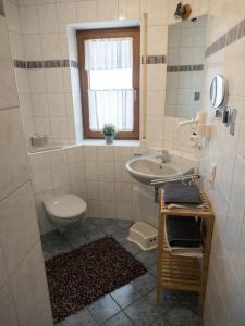 un bagno con lavandino, WC e finestra di Ferienhof Henn a Tauberrettersheim