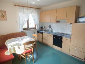 una cucina con tavolo, tavolo e sedia di Ferienhof Henn a Tauberrettersheim