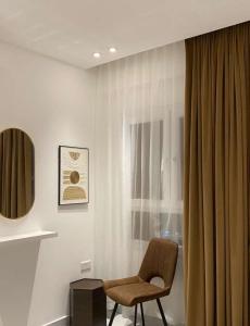 une chaise assise dans une pièce avec fenêtre dans l'établissement AlShmookh apartments, à Mascate