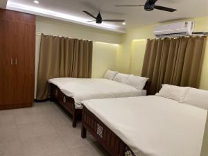 ein Schlafzimmer mit zwei Betten und einer Decke in der Unterkunft Vishnu VAASAM Serviced Apartment Srirangam in Tiruchchirāppalli