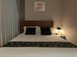 un lit avec deux oreillers dessus dans une chambre dans l'établissement 광안리해수욕장 30초 베이비 맞춤 풀옵션 패밀리 안심 숙소, à Busan