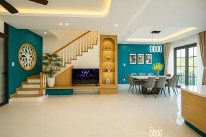 une salle à manger avec des murs bleus et une table à manger dans l'établissement The Moon Villa - NOVAWORLD Phan Thiet, à Bình Tú