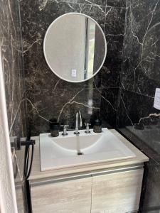 ein Badezimmer mit Waschbecken und Spiegel in der Unterkunft El Descanso in Villa Santa Cruz del Lago + 18 Fotos