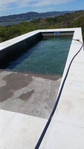 eine Wasserlache mit einem Schlauch an der Seite eines Gebäudes in der Unterkunft El Descanso in Villa Santa Cruz del Lago