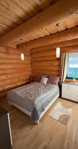 Un dormitorio con una cama en una cabaña de madera. en Chata Lada Repechy, en Bousín