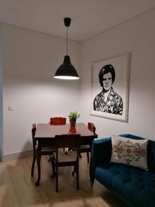 a living room with a table and a blue couch at Casa Da Avo Clementina in Funchal