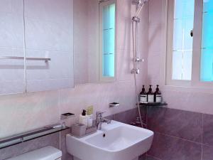 une salle de bain blanche avec un lavabo et un miroir dans l'établissement MAYs GO DUCK Newly built Family Stay KSPO IKEA Lotte World, à Séoul 32 autres photos